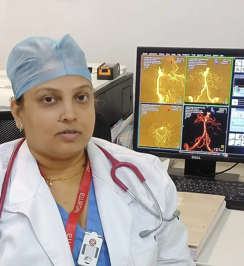 Dr. Swati Chinchure in a white coat, working with brain imaging on a computer screen at Medanta Hospital."